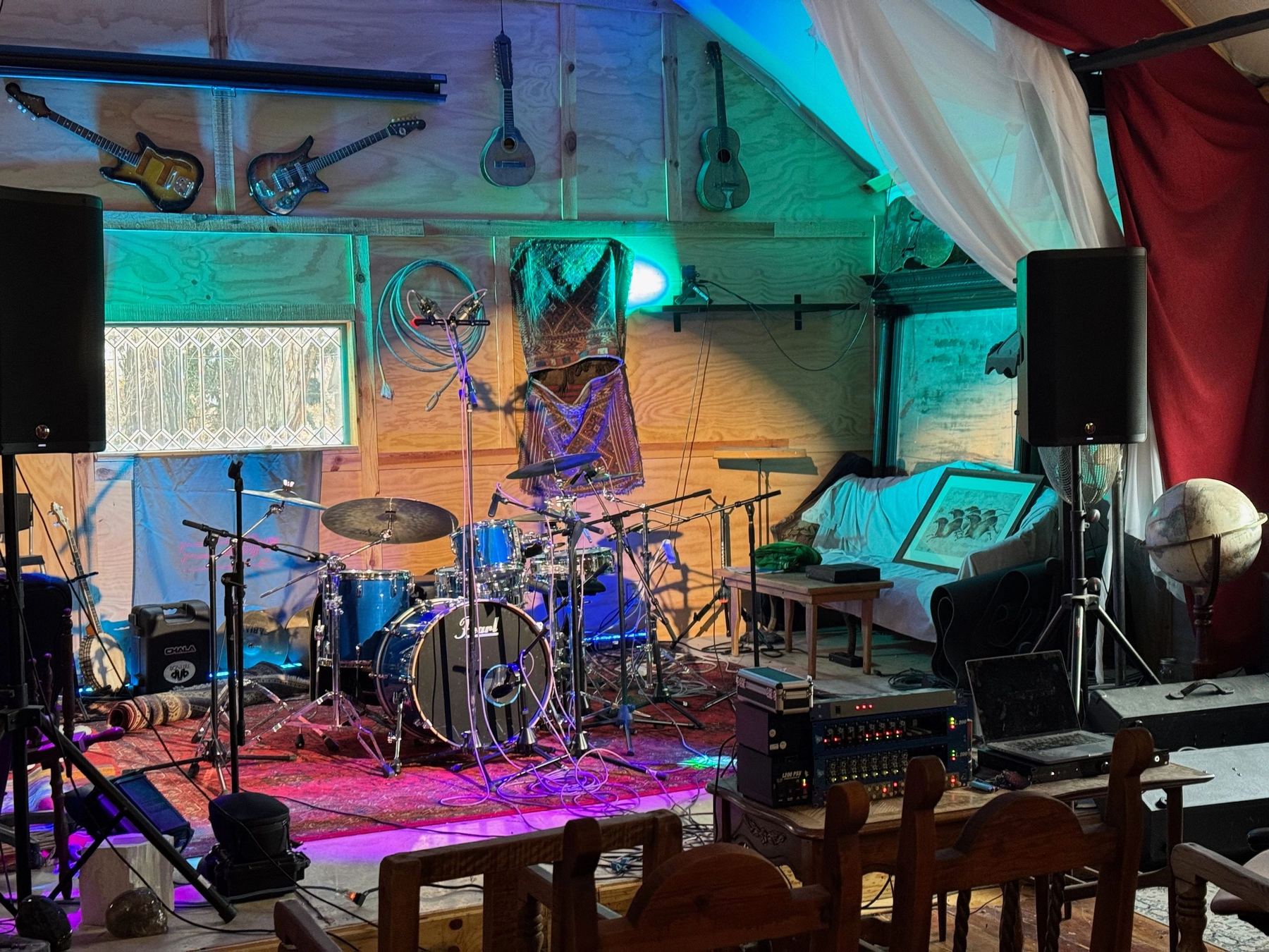 The lit stage with a drum kit and amplifiers set up